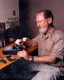 color photo of Paul Legros placing a cassette into a tape recorder/player